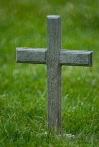 A wooden cross marks a veteran's grave marker in an Ohio cemetery.